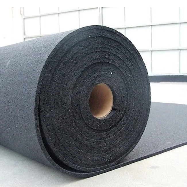 A large roll of black foam underlay on a concrete floor in a bright industrial setting, suitable for garage or shed insulation