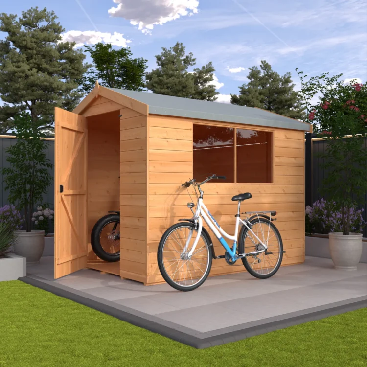 A wooden shed with a bicycle parked outside on a patio in a garden setting with trees and plants around
