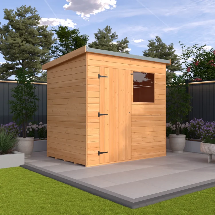 A small wooden shed with a window and double doors on a patio in a garden with trees and flowers under a blue sky