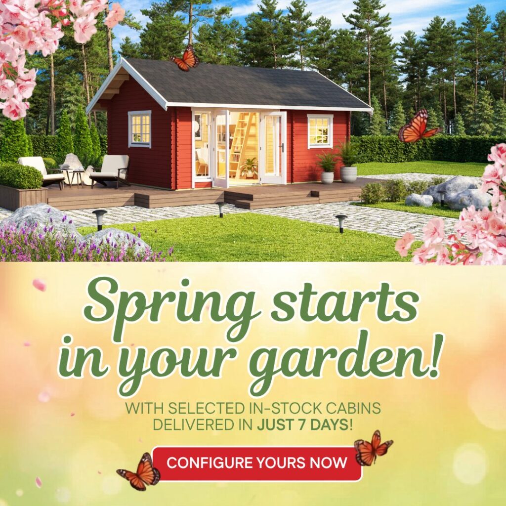 Red log cabin with white trim and deck in garden setting with flowers and butterflies on sunny day